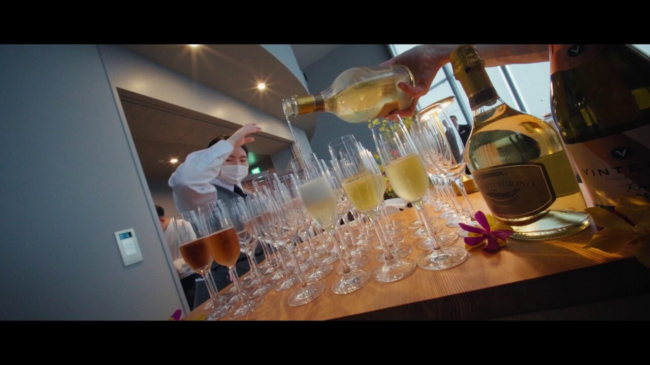 Executive dining setup with Osaka Bay sunset view through floor-to-ceiling windows, 20-person capacity table arrangement