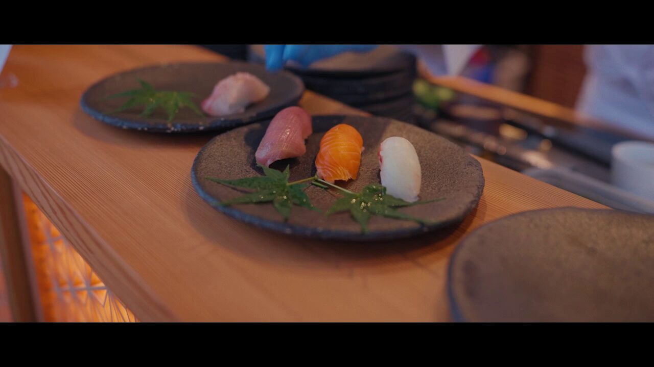 Interactive chef's table experience showing live food preparation for VIP corporate dinner guests in a private venue setting